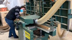 Stagiaire sur machine pendant le stage en ébénisterie avec un ébéniste