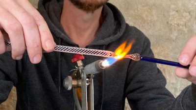 Cyril-John file le verre au chalumeau pendant l'atelier verrerie vers Paris