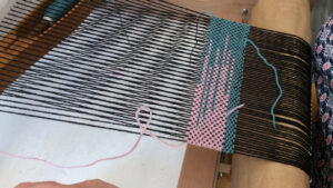 Tissage sur métier à tisser dans l'atelier d'une artisane tisserand pendant un stage