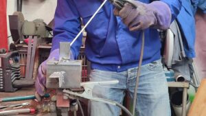 Stagiaire pendant l'atelier de soudure avec un artisan soudeur à Bordeaux