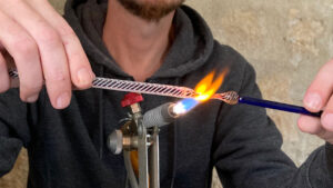 Cyril-John file le verre au chalumeau pendant l'atelier verrerie vers Paris