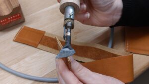 Lissage de tranche pendant l'atelier de maroquinerie à Cholet