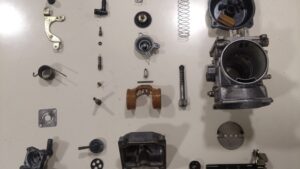 Pièces de carburateur moto pendant le démontage lors d'un atelier