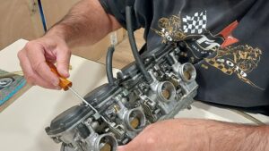 Stagiaire qui démonte et découvre un carburateur moto pendant un stage